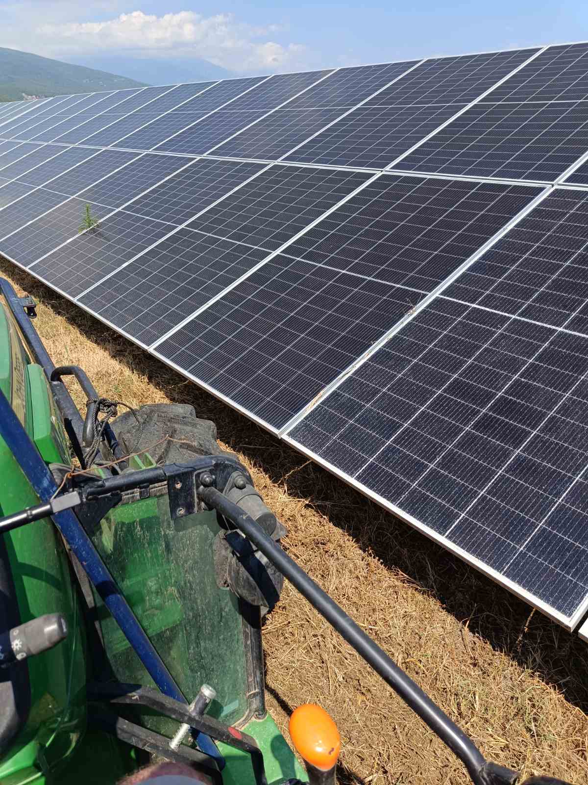 Τρακτέρ John Deere σε αποψίλωση βλάστησης δίπλα σε φωτοβολταϊκά πάνελ