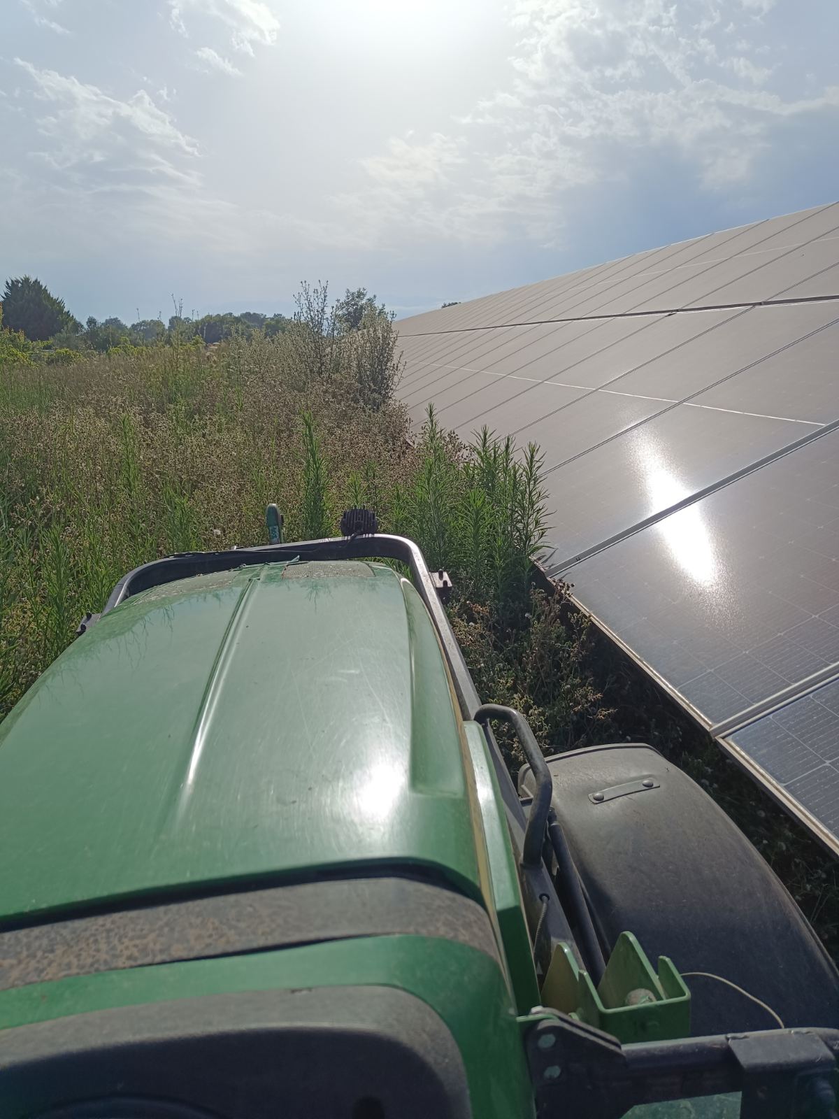 Τρακτέρ John Deere σε αποψίλωση βλάστησης δίπλα σε φωτοβολταϊκά πάνελ