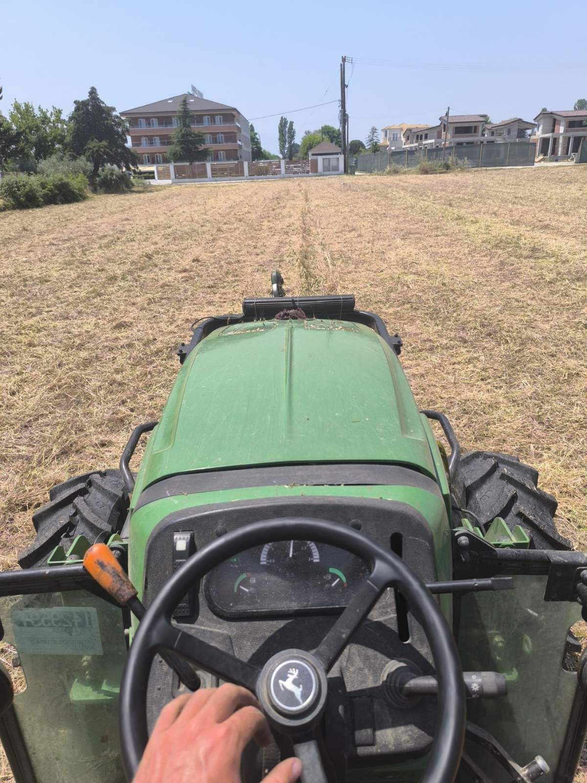 Οδήγηση τρακτέρ John Deere σε εργασίες κοπής χόρτων σε αγροτεμάχιο