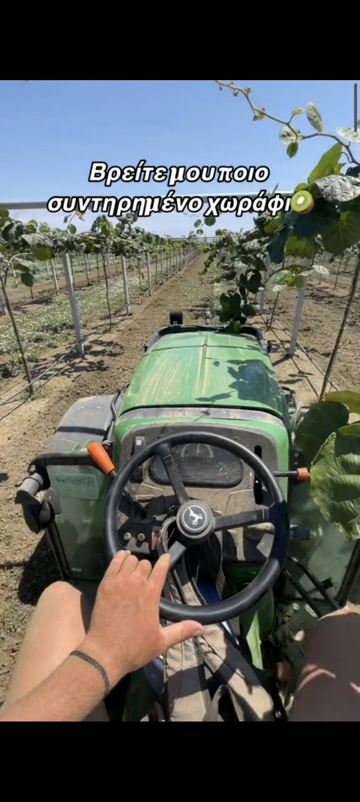 Οδήγηση τρακτέρ John Deere μέσα σε ακτινιδεώνα για καλλιέργεια εδάφους